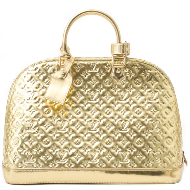 ✨NEW ARRIVAL✨ Louis Vuitton Gold Monogram Miroir Alma GM $3,800.00  Material: PVC Hardware: Gold-tone Colour: Gold Size: 15”L x 6”W x…