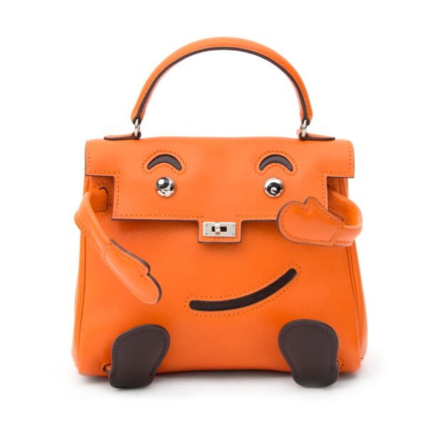 This is the original Hermès Idole Kelly bag or Kelly Doll bag. The playful design and the fact that it is largely discontinued, make this small bag a most sought after collector's item!  The smooth Swift leather gives the signature Hermès Orange color abr