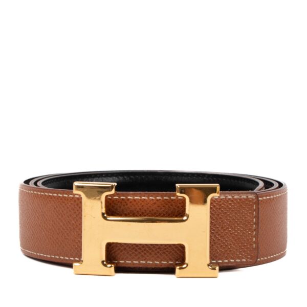 Buy an authentic second hand Hermès black/gold reversible Constance belt in very good condition at Labellov in Antwerp, Knokke, Brussels.