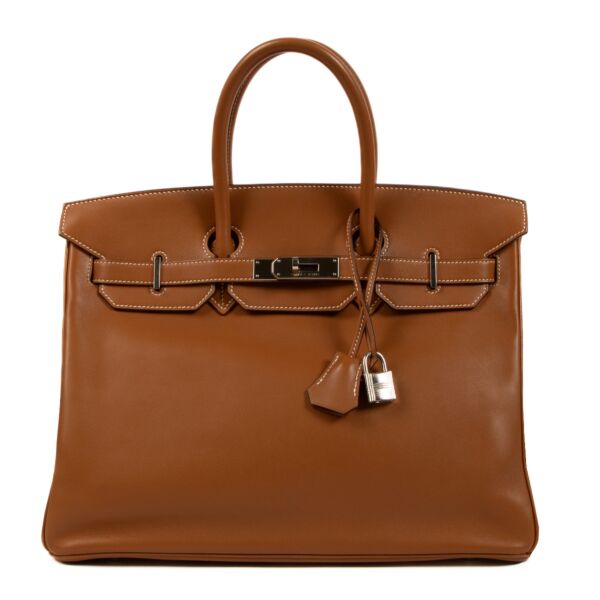 Discover timeless luxury with our Hermès Birkin 35 Swift Gold PHW - a golden statement of elegance