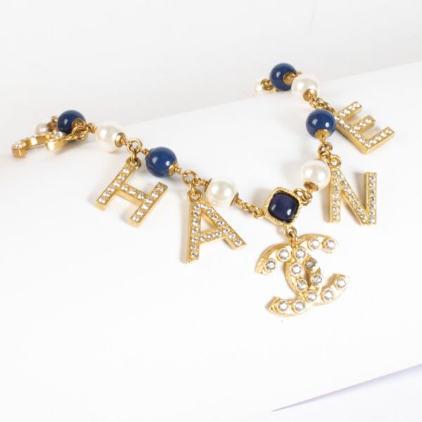 Authentic Chanel gold-tone letter necklace with crystals, pearls and CC logo charm at Labellov.com.
