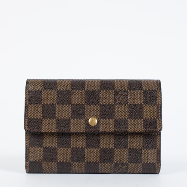 Louis Vuitton Damier Ebene Trésor Wallet in brown checkered canvas with gold-tone snap closure and original dust bag at Labellov.com.