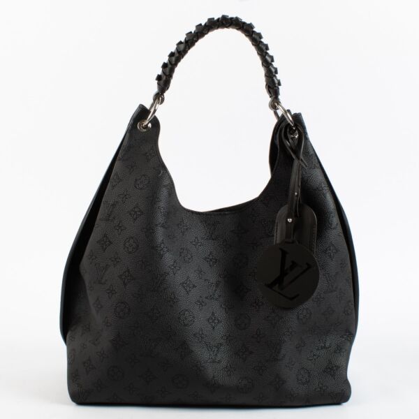 Louis Vuitton Carmel Hobo in black Mahina perforated calf leather with braided handle, silver-tone hardware and roomy interior. Shop now at Labellov.com