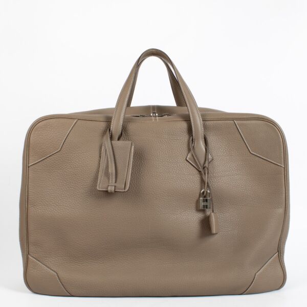 Shop the authentic Hermès Etoupe Clemence PHW Victoria 50 Travel Bag second hand on Labellov.com.