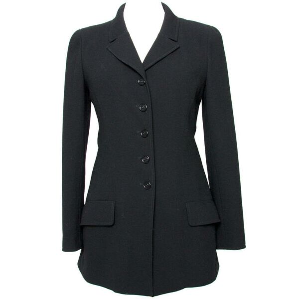 Chanel classic black blazer. Five buttons in the middle and three at the end of each sleeve. The buttons feature the "CC" logo. The lining features white "Chanel" letters and the "CC" logo. Two large pockets at the front.